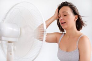 Woman Standing In Front Of Fan