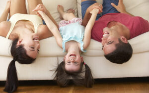 Family Lying Upside Down On Couch